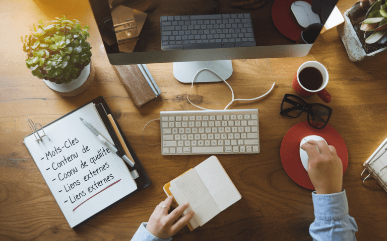 Bureau bien organisé vu du dessus avec clavier, carnet de notes sur SEO comportant