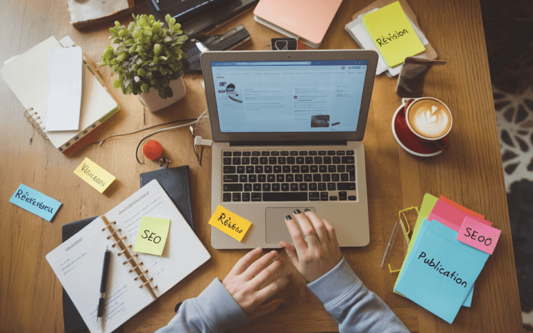 Espace de travail moderne pour créer un blog, avec laptop affichant un éditeur de blog, notes autocollantes SEO, carnet ouvert et café fumant, ambiance inspirante et organisée.