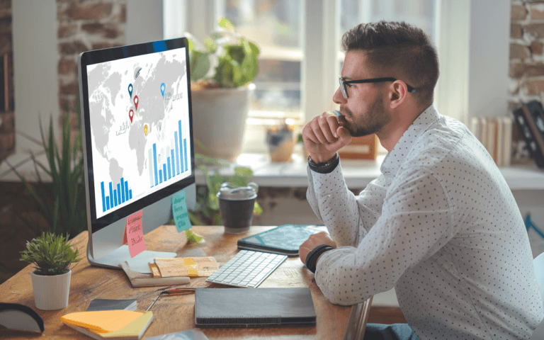 Professionnel réfléchissant devant un ordinateur affichant une carte et des graphiques, symbolisant améliorer référencement Google, ambiance de travail moderne et stratégique.